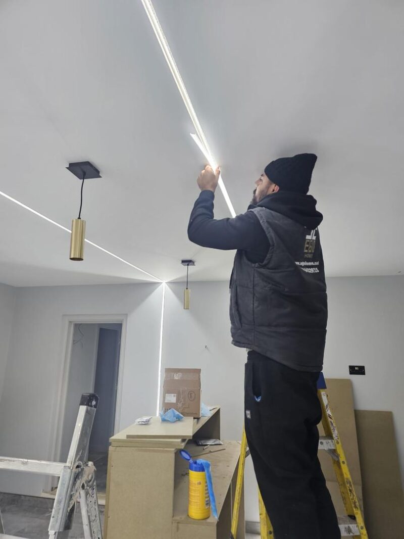 Team in action — coordinating seamlessly to keep the project moving 16 Man installing ceiling lights indoors.